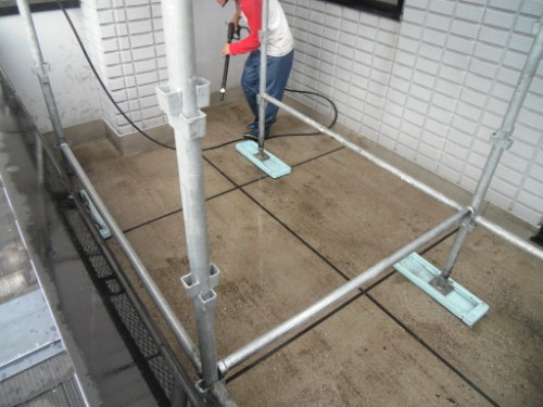 koushin_CIMG2886-1 | 外壁塗装は神奈川県横浜市の塗装職人 Worker mopping a concrete balcony floor inside metal scaffolding