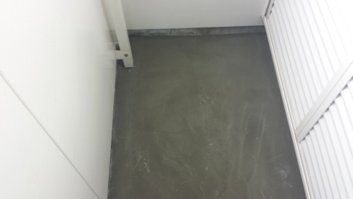 20131128-123033 | 外壁塗装は神奈川県横浜市の塗装職人 Empty small corner with gray concrete floor, white walls, and a white railing along the right side.