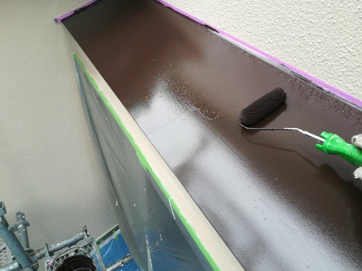 庇天端へチョコレート色を塗り重ねる作業