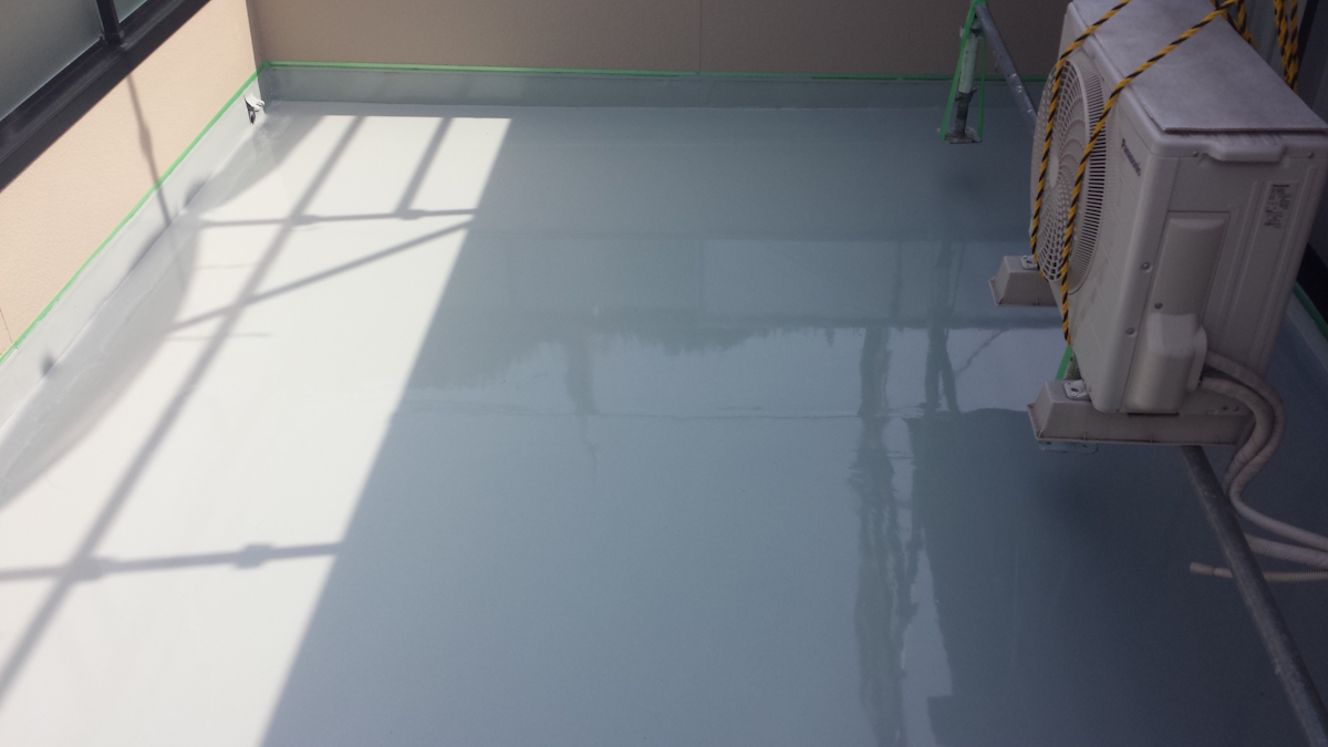 METADATA-START | 外壁塗装は神奈川県横浜市の塗装職人 Rooftop balcony with a glossy light blue epoxy floor, shadows from railing, and an outdoor air conditioner on the right.