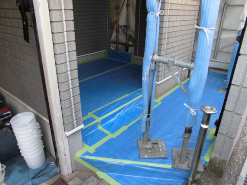 白い縦目地とブルーシートで養生した玄関まわり