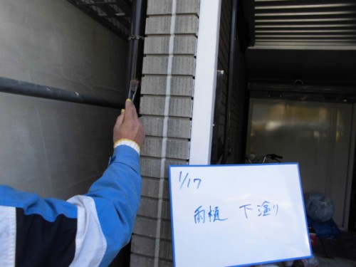 縦樋に刷毛で下塗りをする様子