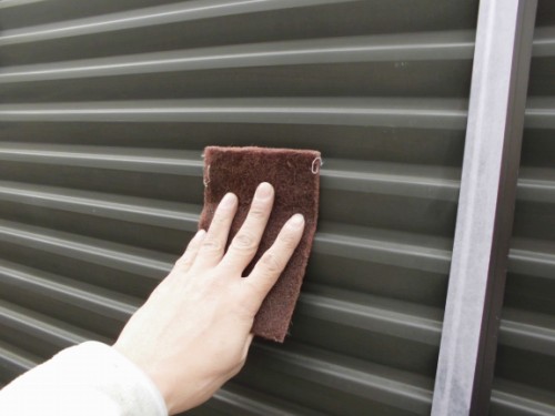 雨戸の表面をハンドパッドで研磨する様子