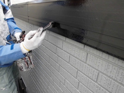 外壁際の幕板を刷毛で上塗りする様子