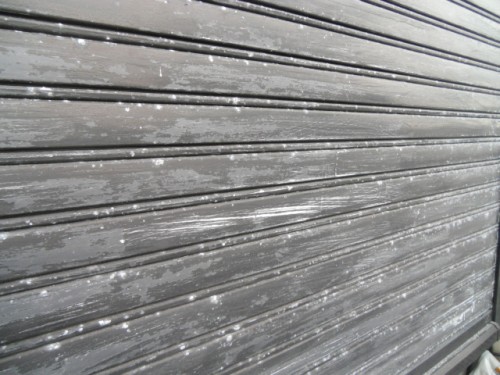 koushin_CIMG1288-1 | 外壁塗装は神奈川県横浜市の塗装職人 Grey metal roll-up shutter door with horizontal slats, showing chipped paint and small white specks across the surface.