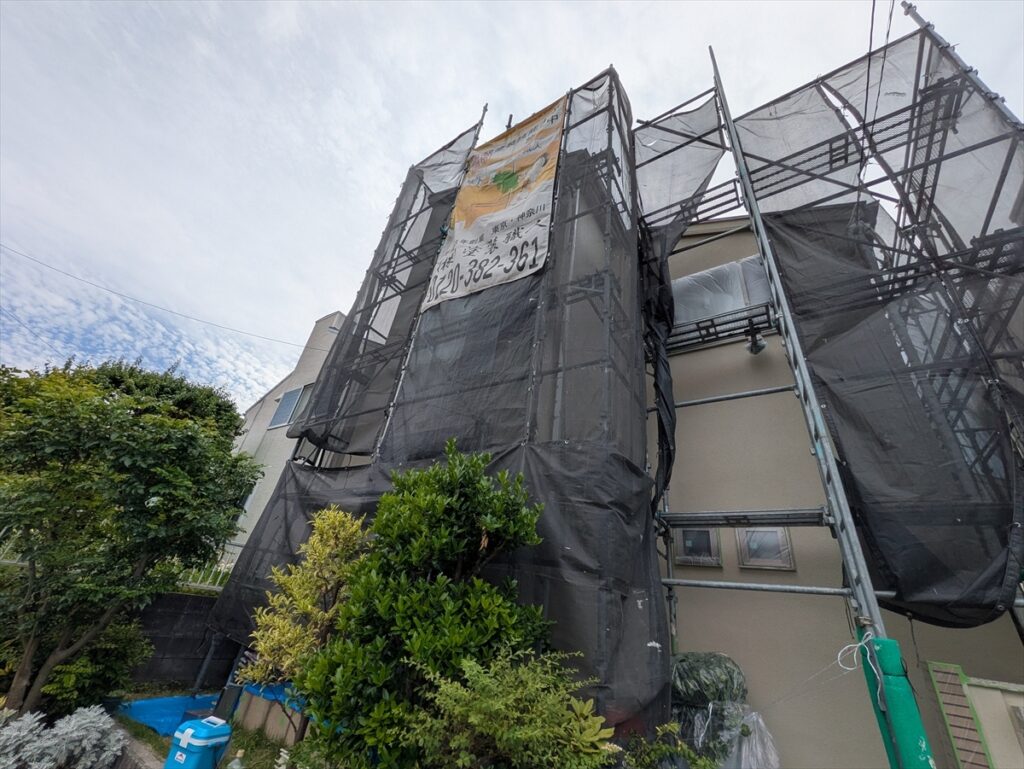 足場と飛散防止シート越しの建物正面