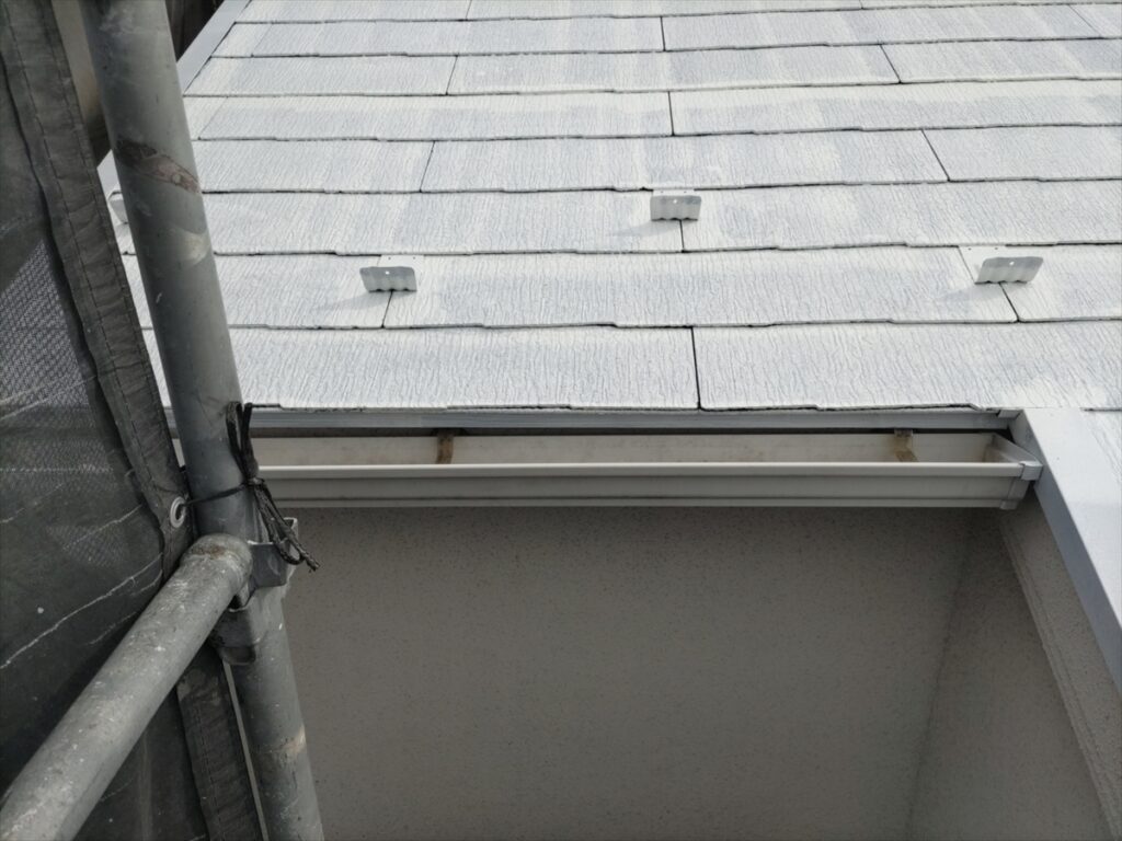 白く下塗りした軒先の屋根材と突き出した金具