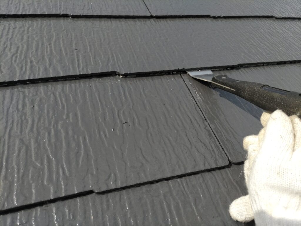スレートの重なりの縁に道具を入れる手元