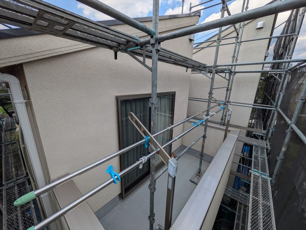 midori-202605-03-001 | 外壁塗装は神奈川県横浜市の塗装職人 足場越しに見たバルコニー内側の壁と窓