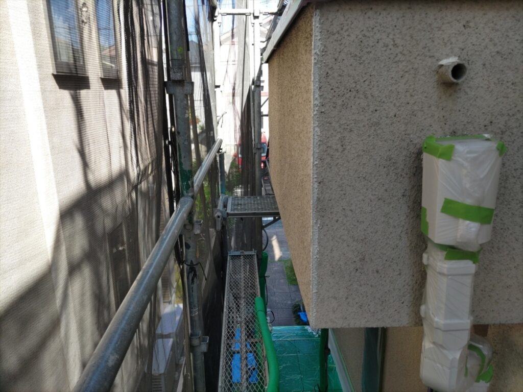 midori-202605-03-013 | 外壁塗装は神奈川県横浜市の塗装職人 養生した配管と外壁角部の白い補修跡