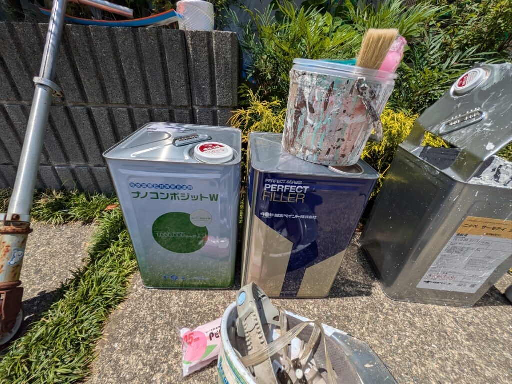 材料缶と刷毛を並べた作業場所