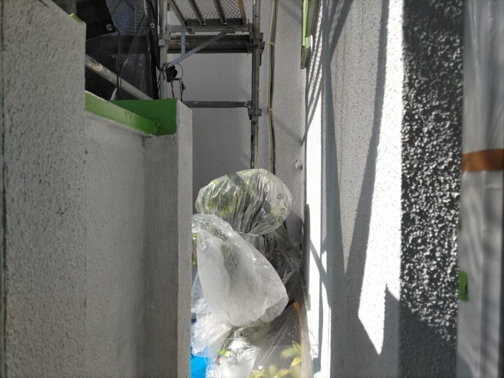 養生された植栽と器具の近くの白い外壁