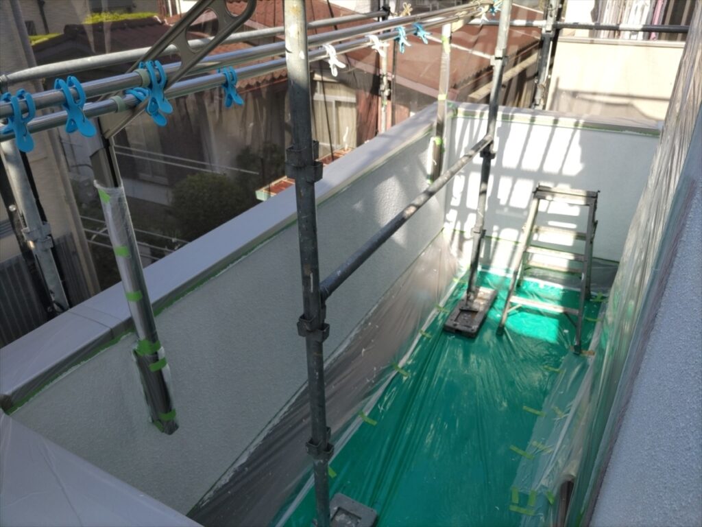 白い立ち上がり壁と緑色の床養生