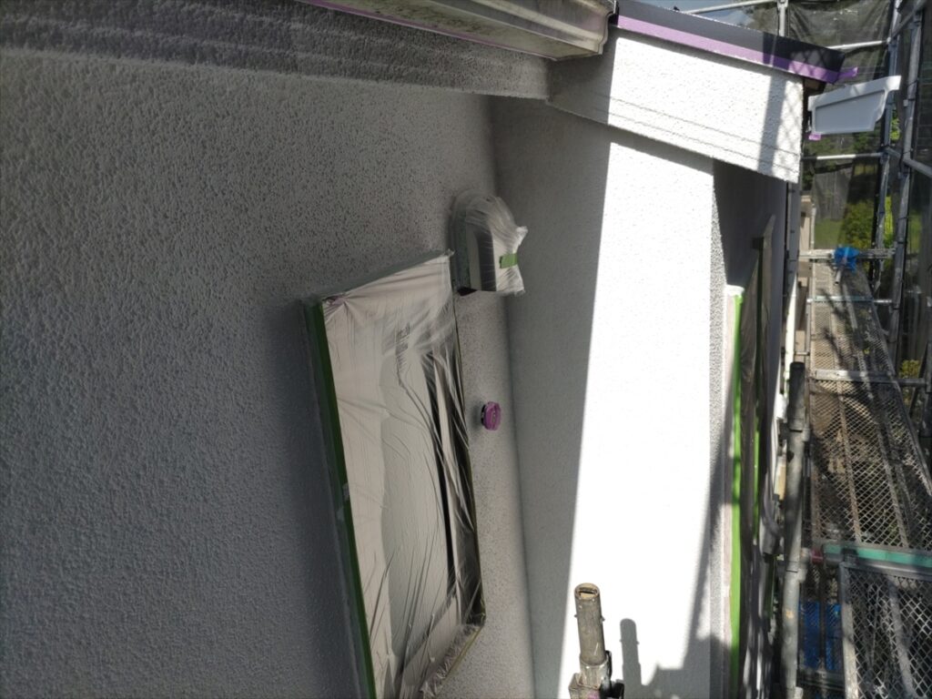 養生した窓と壁付け器具の周囲の白い壁面
