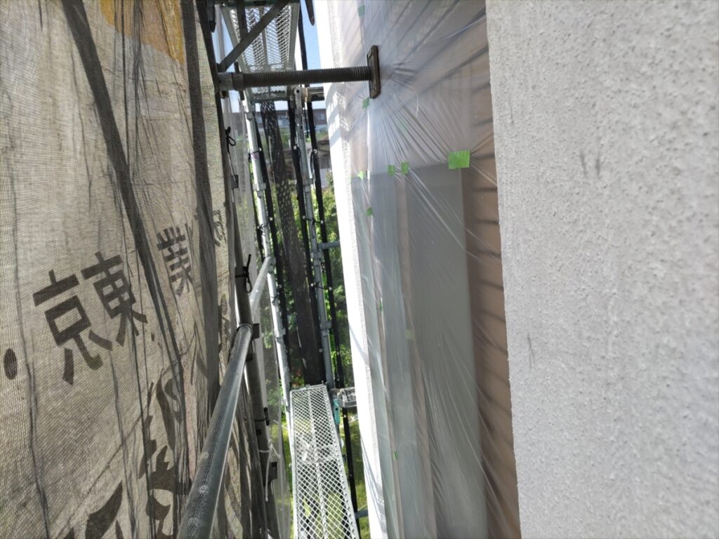 狭い通路側の白い外壁と養生した開口部