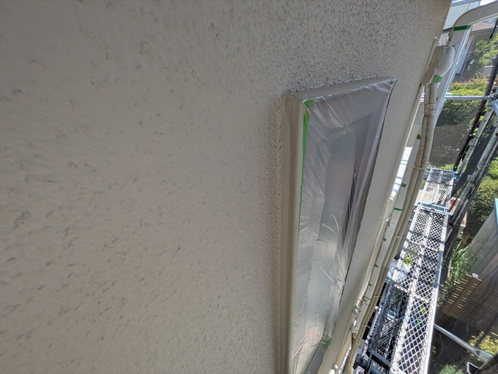 養生した縦長窓と周囲の外壁