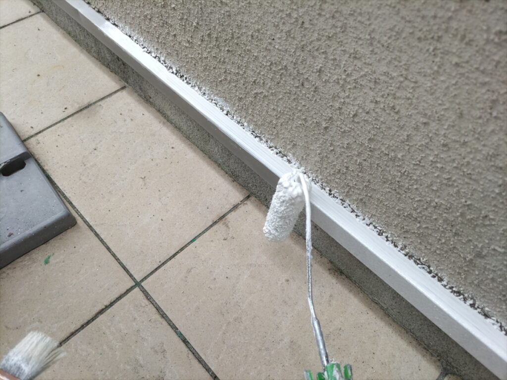 水切りを小型ローラーで白く塗る様子