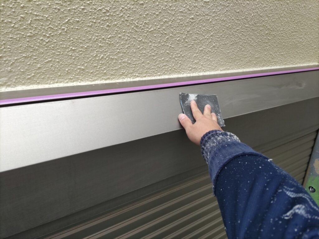 シャッターボックス正面に研磨材を当てる手元