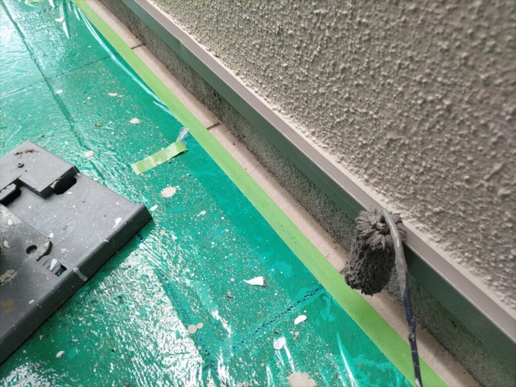 養生した床の上で水切りを刷毛塗りする手元