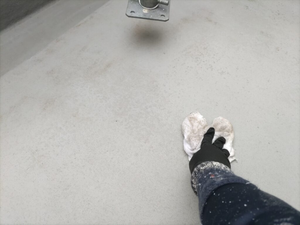 白い布でベランダ床面を拭く手元