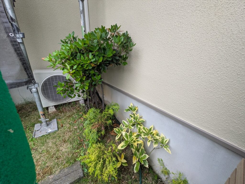 植栽と室外機の背面に続く水切りと基礎
