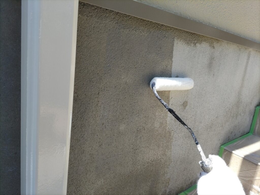 基礎の表面へ小型ローラーで下塗りする手元
