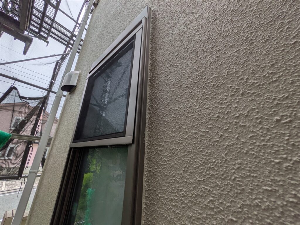 窓枠に沿う塗り分けと凹凸のある外壁