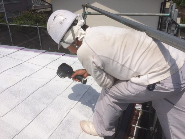 サーモグラフィーで屋根表面を測る職人