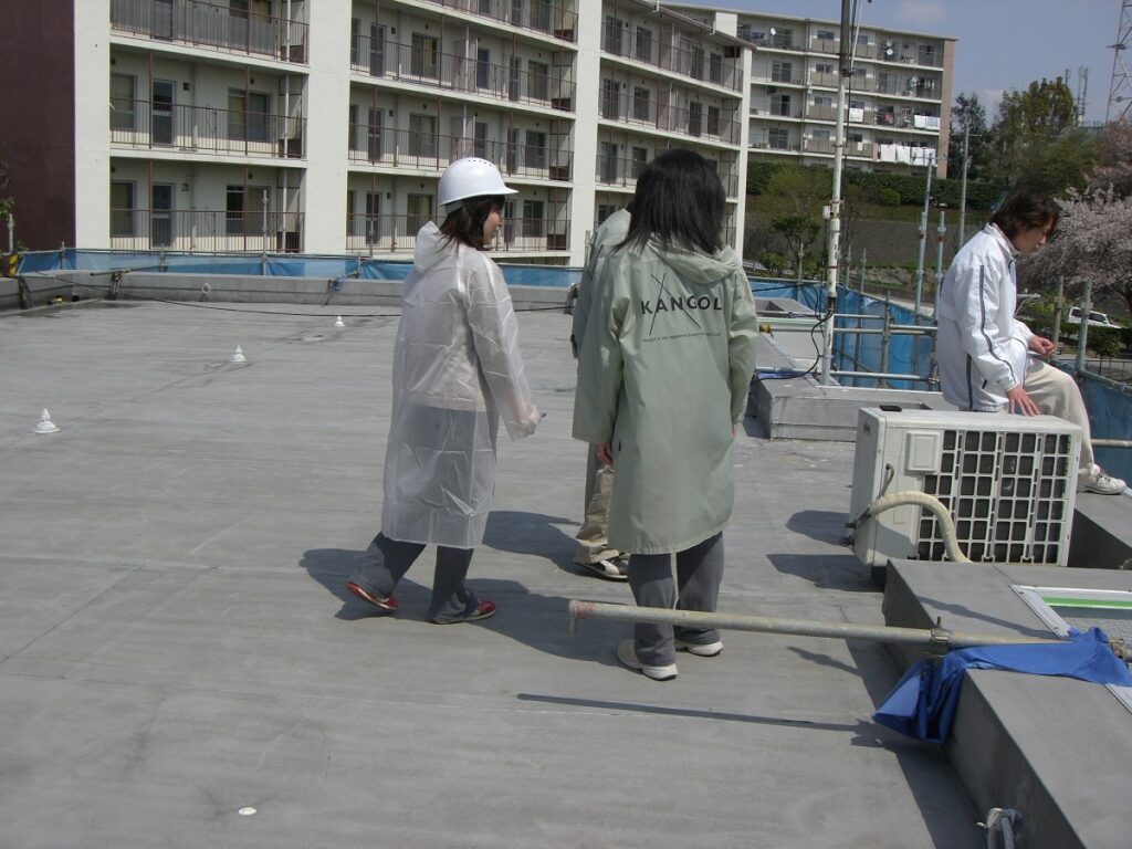 屋上で点検をする住民