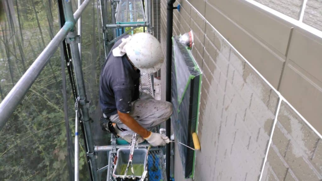株式会社塗装職人 外壁をローラーで塗っている職人